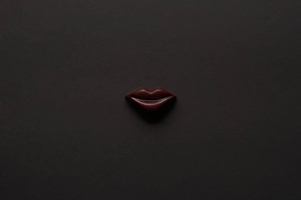 Top view of tasty chocolate lips on black background — Stock Photo