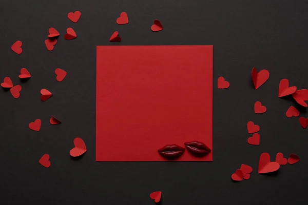 Vista superior de la tarjeta vacía roja con labios de chocolate y corazones cortados en papel - foto de stock