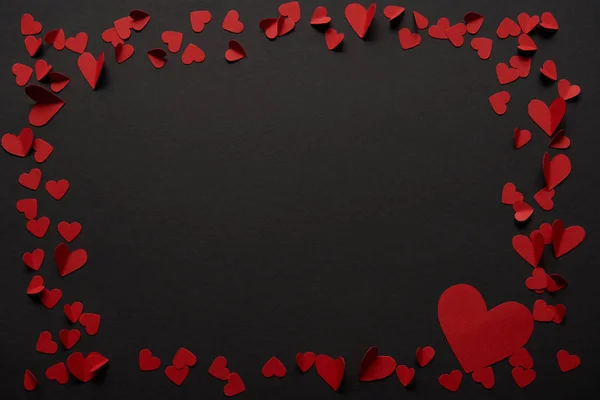 Black background with copy space and paper cut red hearts — Stock Photo