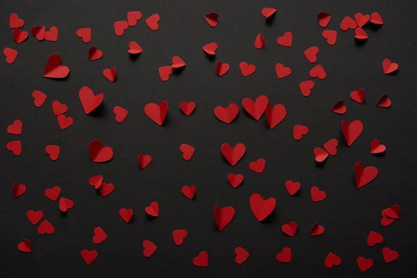 Seamless black background with copy space and paper cut red hearts — Stock Photo