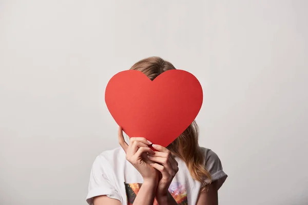 Young woman with obscure face and empty paper cut heart card isolated on grey — Stock Photo