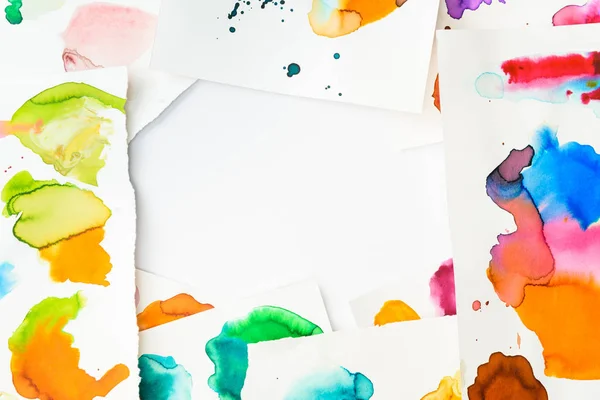 Top view of frame with abstract watercolor spills on papers on white background — Stock Photo