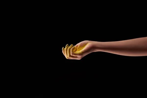 Обрезанный вид женщины и желтый ореховый порошок изолированы на черном — стоковое фото