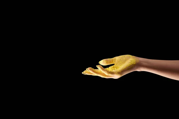 Vue recadrée de la femme adulte avec poudre holi jaune à la main isolé sur noir — Photo de stock