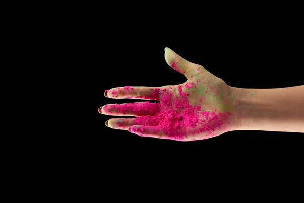 Vista recortada de la mujer adulta con polvo de holi rosa aislado en negro - foto de stock