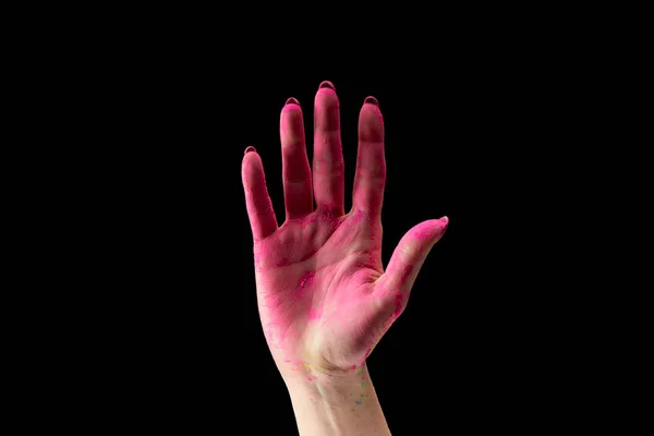 Cropped view of adult woman showing pink holi powder on hand isolated on black — Stock Photo