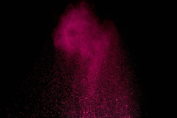 Pink holi powder in air on black background — Stock Photo