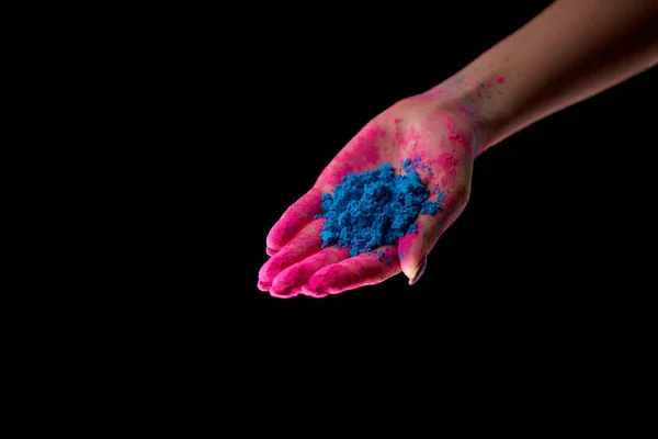 Vue recadrée de femme adulte tenant la poudre holi bleue isolée sur noir — Photo de stock