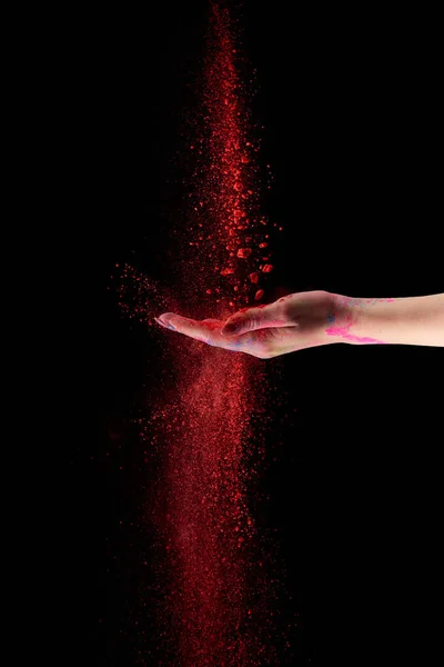 Cropped view of adult woman with red holi powder on black background — Stock Photo