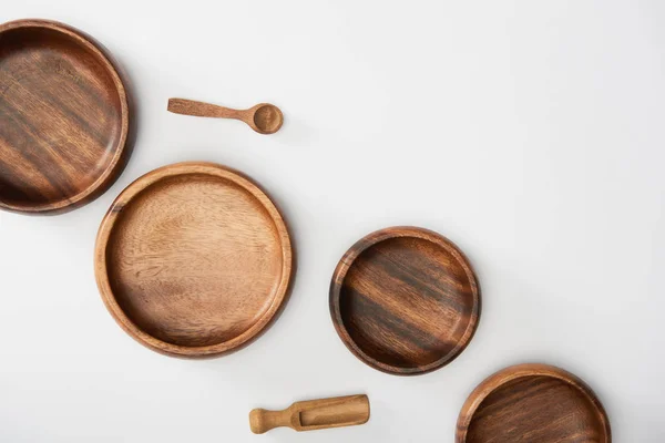 Top view of wooden bowls, spoon and spatula on white background — Stock Photo