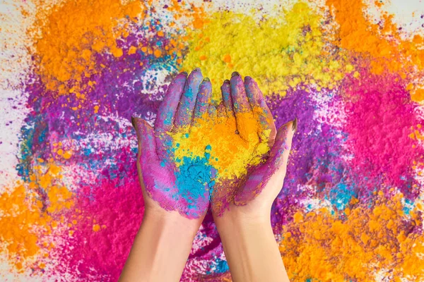 Vista recortada de la mujer sosteniendo polvo de holi multicolor - foto de stock