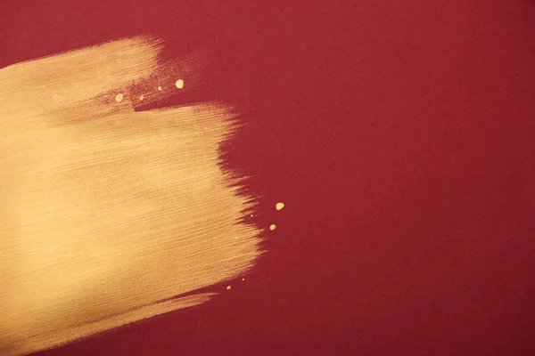 Artistic burgundy wallpaper with golden brushstroke and copy space — Stock Photo