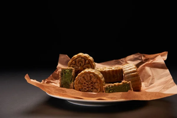 Traditional chinese mooncakes on plate isolated on black with copy space — Stock Photo