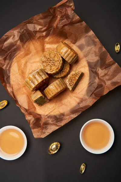 Top view of chinese mooncakes with tea cups isolated on black — Stock Photo