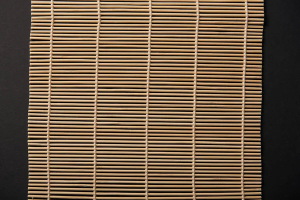 Vue de dessus du tapis de table en bambou isolé sur noir — Photo de stock