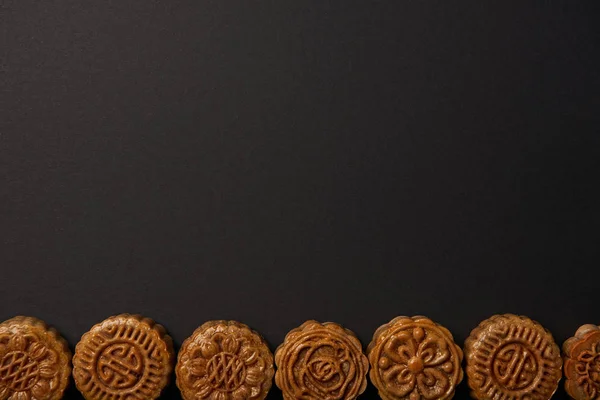 Top view of traditional chinese mooncakes isolated on black with copy space — Stock Photo