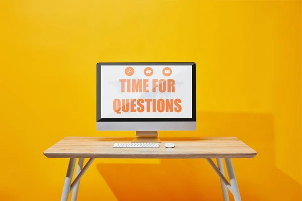 Computer with keyboard and mouse at wooden table with time for questions lettering on screen — Stock Photo