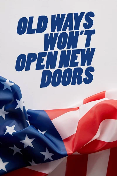 Top view of united states of america flag and old ways wont open new doors quote on white surface — Stock Photo