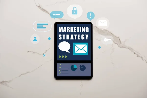 Вид зверху цифрового планшета з ілюстрацією маркетингової стратегії на білій мармуровій поверхні — стокове фото