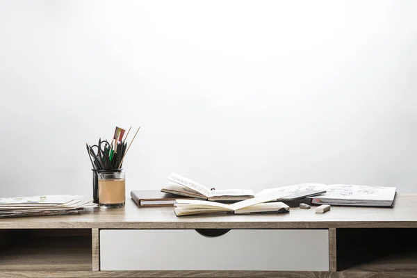 Selective focus of wooden table with albums and drawing utensils — Stock Photo