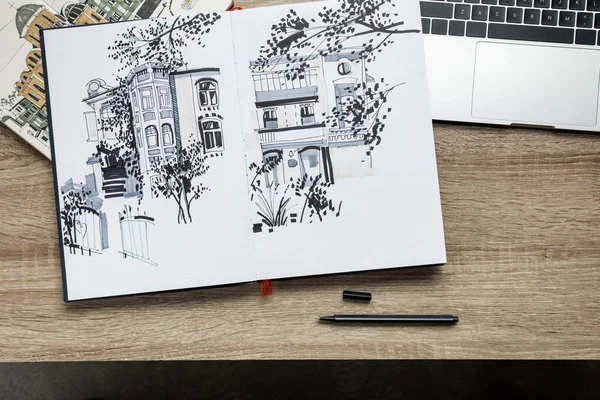 Vista dall'alto di disegni in album e laptop su sfondo di legno — Foto stock