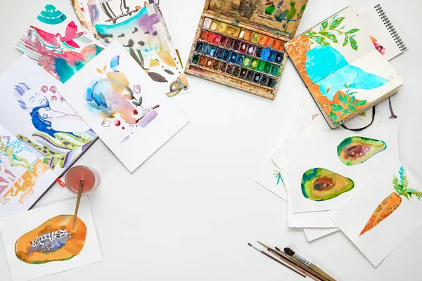 Top view of colorful watercolor paintings and drawing utensils — Stock Photo