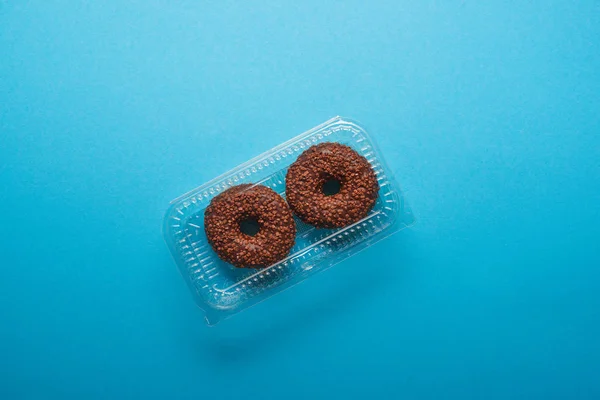 Vista superior de las rosquillas de chocolate sobre fondo azul - foto de stock