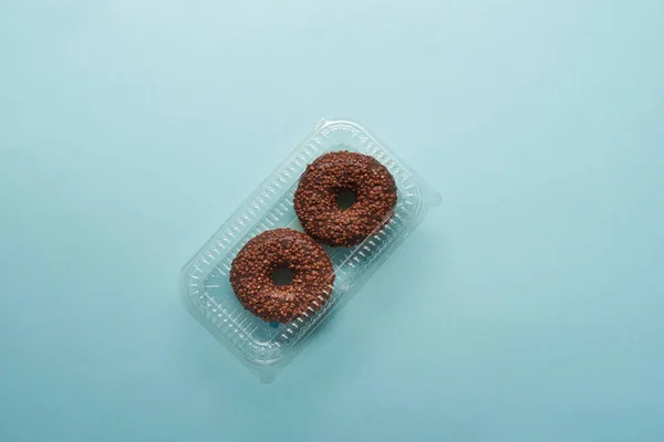 Top view of tasty chocolate donuts on blue background — Stock Photo