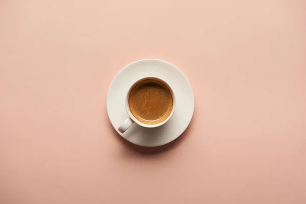 Draufsicht auf leckeren Espresso in weißer Tasse auf rosa Hintergrund — Stockfoto