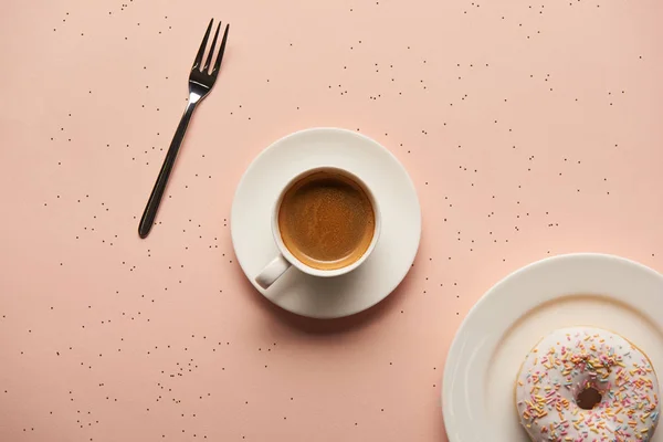 Top view of sweet doughnut near cup of coffee and fork on pink background — Stock Photo