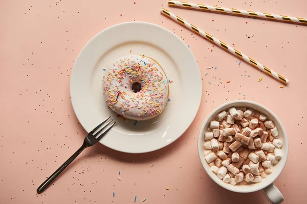 Draufsicht auf süßen Kakao mit Marshmallows in der Nähe von Donut auf rosa Hintergrund — Stockfoto