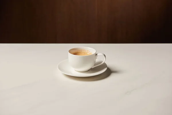 Cup of hot aromatic coffee on white table — Stock Photo