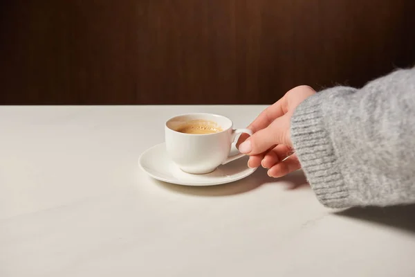 Abgeschnittene Ansicht einer Frau, die eine Tasse mit aromatischem Kaffee hält — Stockfoto