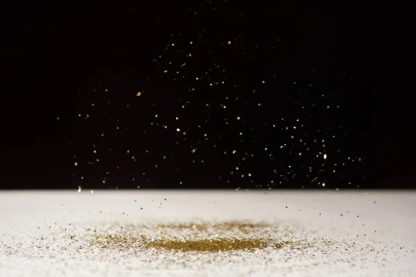 Selective focus of white table with bright sparkles isolated on black — Stock Photo