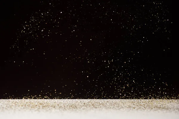 White table with bright shiny sparkles isolated on black — Stock Photo