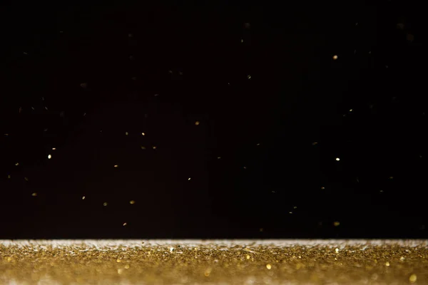 Table with bright golden sparkles isolated on black — Stock Photo