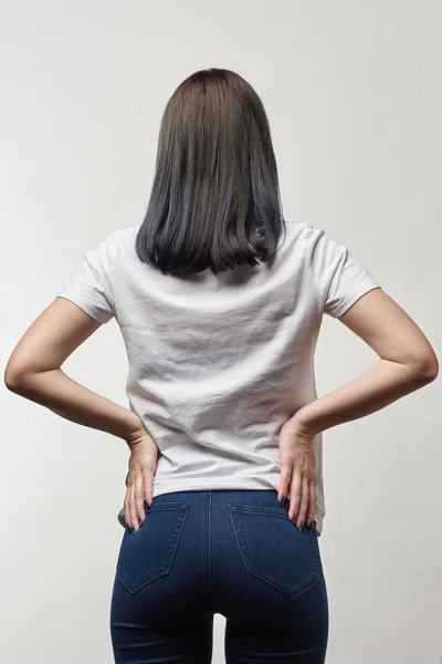 Visão traseira da jovem mulher em t-shirt branca com espaço de cópia isolado em branco — Fotografia de Stock