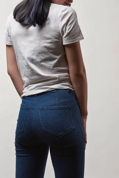 Rückansicht einer jungen Frau in Jeans und weißem T-Shirt mit Kopierraum isoliert auf weiß — Stockfoto