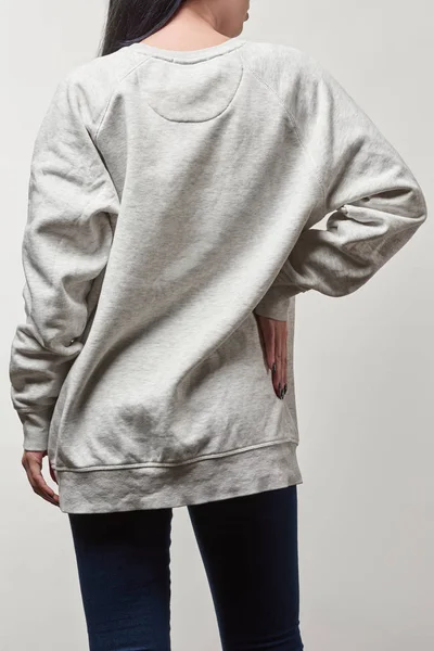 Back view of young woman in grey hoodie with copy space isolated on white — Stock Photo