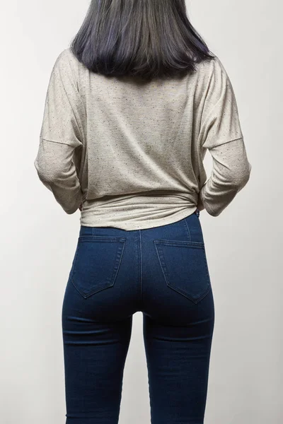 Back view of young woman in grey long sleeve with copy space isolated on white — Stock Photo