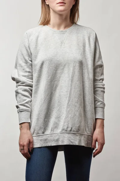 Обрізаний вид на молоду жінку в сірому светрі з копіювальним простором ізольовано на білому — стокове фото