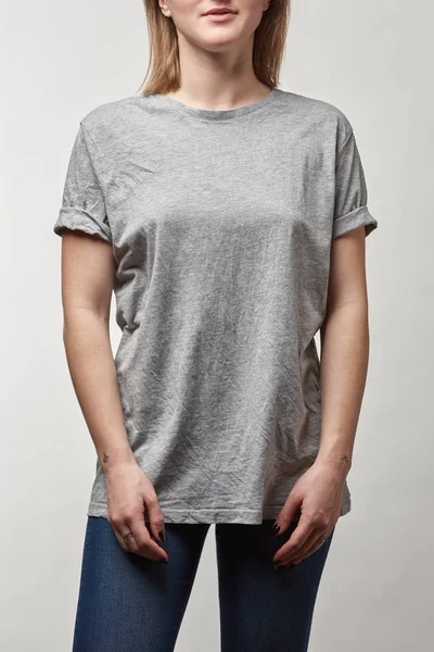 Vista recortada de mujer joven en camiseta gris con espacio de copia aislado en blanco - foto de stock