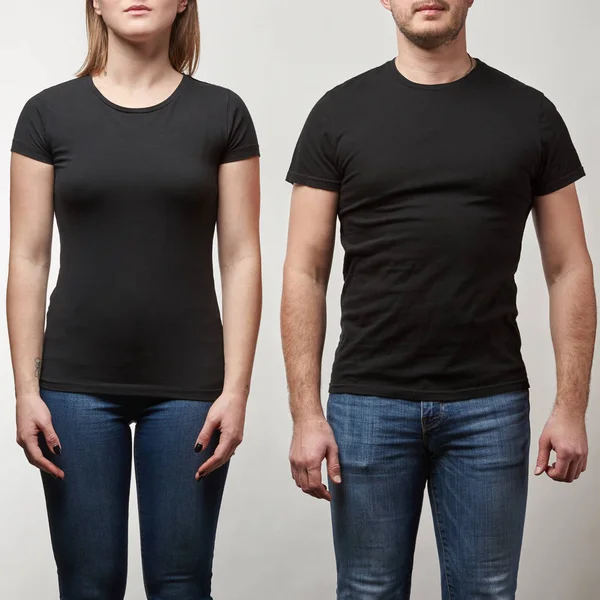 Vista recortada de hombre y mujer jóvenes en camisetas negras con espacio de copia aislado en gris - foto de stock