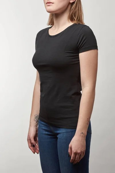 Teilansicht einer jungen Frau in schwarzem Baumwoll-T-Shirt mit Kopierraum auf weißem Hintergrund — Stockfoto