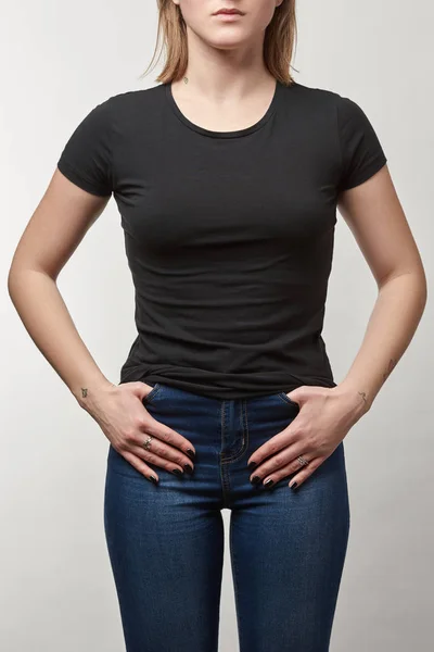 Teilansicht einer jungen Frau in schwarzem Baumwoll-T-Shirt mit Kopierraum auf weißem Hintergrund — Stockfoto