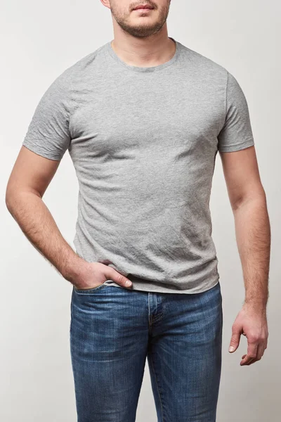Vista ritagliata dell'uomo con mano in tasca in t-shirt con spazio copia isolato su grigio — Foto stock