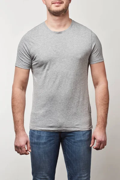 Vista parziale dell'uomo in denim e t-shirt con spazio copia isolato su grigio — Foto stock
