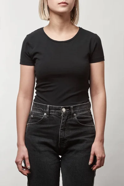 Vista parcial de mujer joven en camiseta negra casual con espacio de copia aislado en blanco - foto de stock