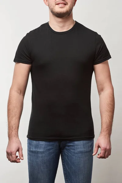 Partial view of man in denim and black t-shirt with copy space isolated on grey — Stock Photo