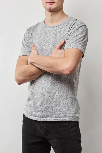Partial view of man with arms crossed in t-shirt with copy space isolated on grey — Stock Photo